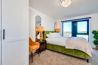a bedroom with a bed and a desk and a window at Luxury City Escape - Brand New Stylish 2 Bedroom Apartment with Parking in Liverpool