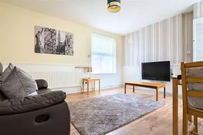 a living room with a couch and a television at Travellers Economic Stays in Orrell Park in Liverpool