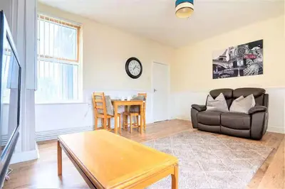 a living room with a couch and a table at Travellers Economic Stays in Orrell Park in Liverpool