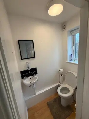 a white bathroom with a toilet and a sink at Beautiful park view town house in Wigan