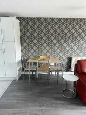 a dining room with tables and chairs against a wall at Beautiful park view town house in Wigan