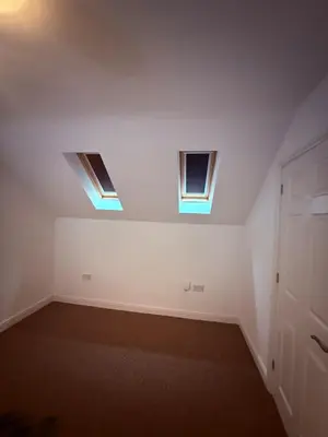 an empty room with two windows and a door at Beautiful park view town house in Wigan