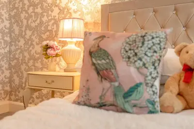 a teddy bear sitting on a bed with a pillow at Southport Rabbit Retreat in Southport