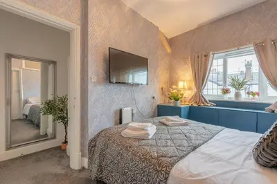 a bedroom with a bed and a tv on the wall at Southport Rabbit Retreat in Southport