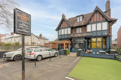 a car parked in a parking lot in front of a building at Southport Rabbit Retreat in Southport