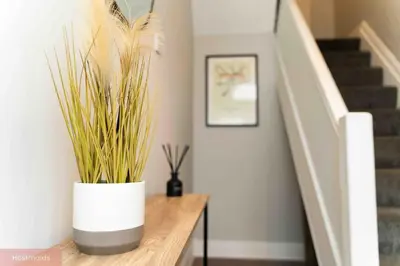 a staircase with a white vase with plants on a table at Apartment near Blackpool Central & Pleasure Beach in Blackpool