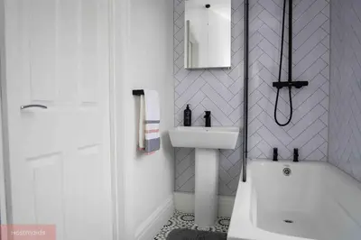 a white bathroom with a sink and a bath tub at Apartment near Blackpool Central & Pleasure Beach in Blackpool