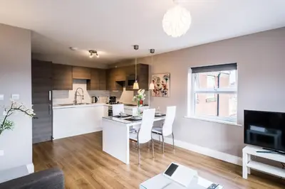 a kitchen and living room with a table and chairs at Fishergate Apartments in Preston