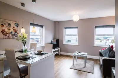 a kitchen and living room with a table and chairs at Fishergate Apartments in Preston