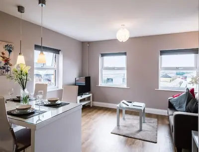 a kitchen and living room with a table and a couch at Fishergate Apartments in Preston