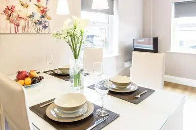a dining room with a table with plates and glasses at Fishergate Apartments in Preston