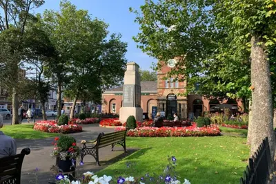 a building with a clock tower in the middle of a park at Fairhaven View Apartments - Lytham St Annes in Lytham St Annes