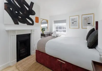 a bedroom with a large bed and a fireplace at Flatzy - City Centre Mansion 2, Sleeps 22, 4 Baths in Liverpool