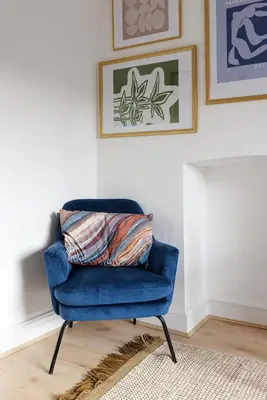 a blue chair sitting in a room with a rug at Flatzy - City Centre Mansion 2, Sleeps 22, 4 Baths in Liverpool