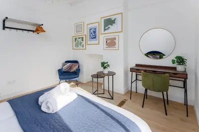 a bedroom with a bed and a desk and a mirror at Flatzy - City Centre Mansion 2, Sleeps 22, 4 Baths in Liverpool