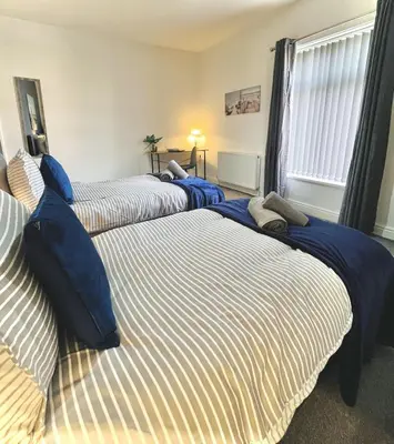 a bedroom with three beds with blue and white sheets at Ideal 3 bed pay-as-you-stay home in Wigan sleeps 6 in Wigan