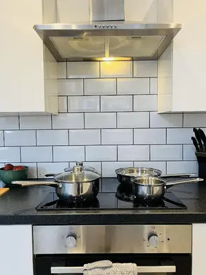 three pots on top of a stove in a kitchen at Ideal 3 bed pay-as-you-stay home in Wigan sleeps 6 in Wigan
