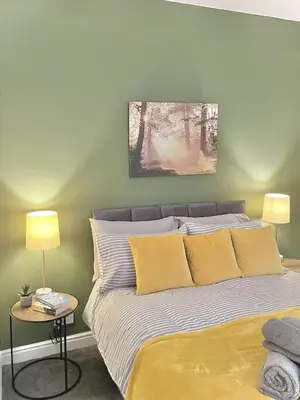 a bedroom with a bed with yellow pillows at Ideal 3 bed pay-as-you-stay home in Wigan sleeps 6 in Wigan