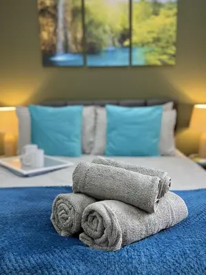a pile of towels sitting on top of a bed at Ideal 3 bed pay-as-you-stay home in Wigan sleeps 6 in Wigan