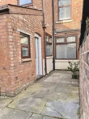 a brick building with a white door and a window at Ideal 3 bed pay-as-you-stay home in Wigan sleeps 6 in Wigan