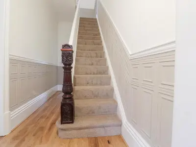 a staircase in a home with white walls and wooden floors at 163 Manchester Road in Accrington