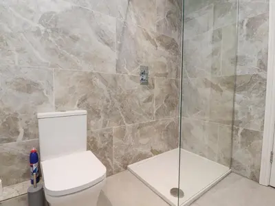 a bathroom with a toilet and a glass shower at 163 Manchester Road in Accrington