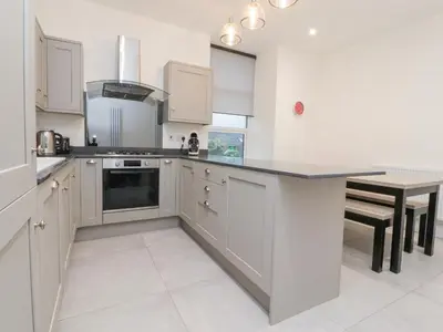 a kitchen with white cabinets and a black counter top at 163 Manchester Road in Accrington