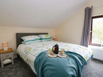 a bedroom with a bed with a tray of food on it at The Old Surgery in Grange Over Sands