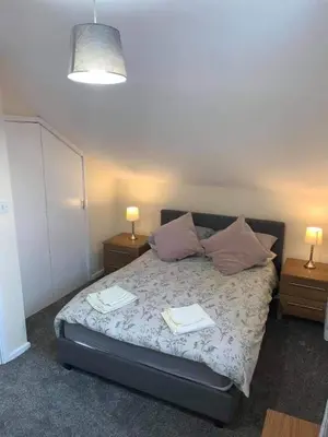 a bedroom with a bed with two tables and two lamps at The Old Surgery in Grange Over Sands
