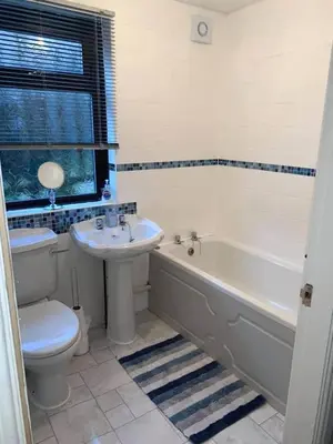 a bathroom with a tub and a toilet and a sink at The Old Surgery in Grange Over Sands