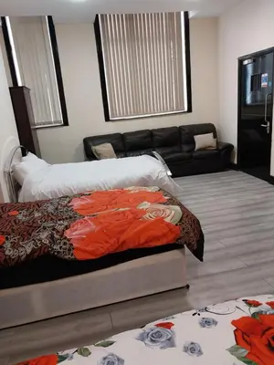 a living room with a bed and a couch at Queens Hotel in Blackburn