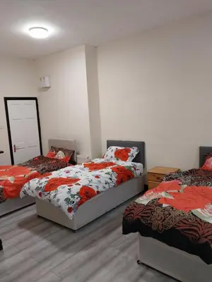 a room with two beds and two bedsskirts at Queens Hotel in Blackburn