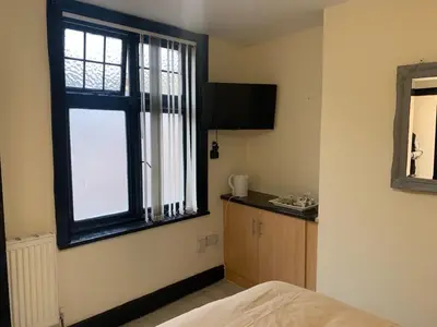 a room with a bed and a window and a counter at Queens Hotel in Blackburn