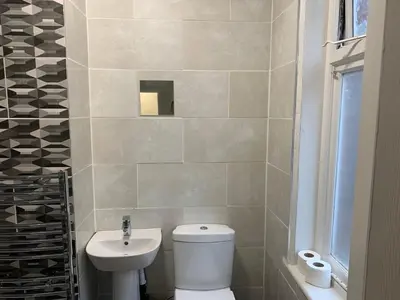 a bathroom with a white toilet and a sink at Queens Hotel in Blackburn