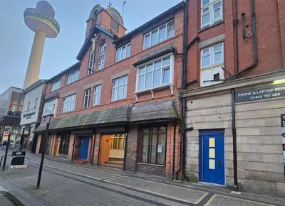 a street with buildings and a tower in the background at Liverpool city center Apartments Dawson Street in Liverpool