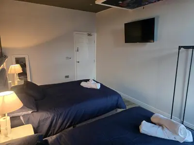 a bedroom with two beds and a flat screen tv at Liverpool city center Apartments Dawson Street in Liverpool