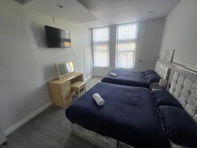 a bedroom with three beds and a television in it at Liverpool city center Apartments Dawson Street in Liverpool