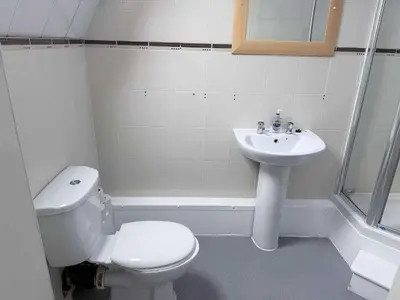 a white bathroom with a toilet and a sink at Twelfth Man Accommodation part of The Twelfth Man Public House in Liverpool