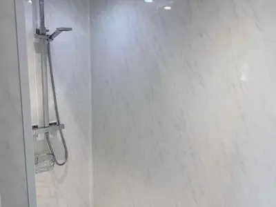 a bathroom with a shower with white tile at Twelfth Man Accommodation part of The Twelfth Man Public House in Liverpool