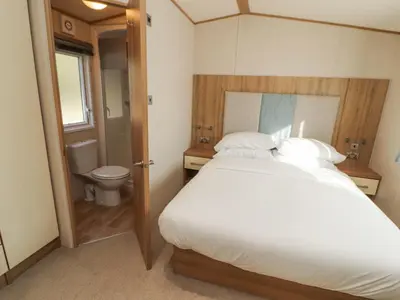 a bedroom with a large bed and a toilet at Lodge 1 in Carnforth