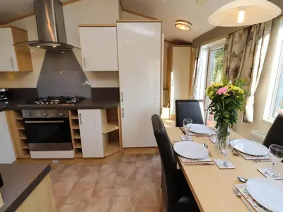 a kitchen with a table with chairs and a dining room at Lodge 2 in Carnforth