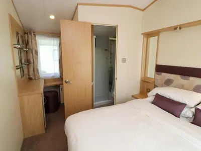 a small bedroom with a bed and a shower at Lodge 2 in Carnforth