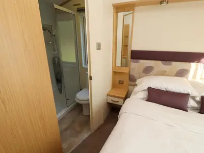 a bathroom with a bed and a shower and a toilet at Lodge 2 in Carnforth