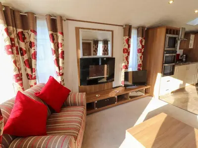 a living room with a couch and a television at Lodge 4 in Carnforth