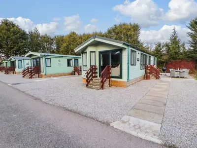a row of mobile homes on a gravel road at Lodge 4 in Carnforth