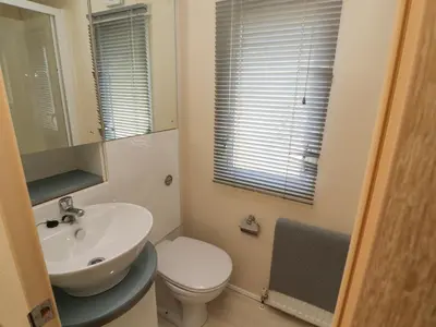 a bathroom with a sink and a toilet and a mirror at Lodge 3 in Carnforth