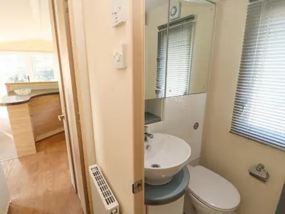 a small bathroom with a toilet and a sink at Lodge 3 in Carnforth