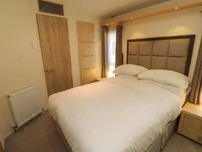 a bedroom with a large white bed and a window at Lodge 3 in Carnforth