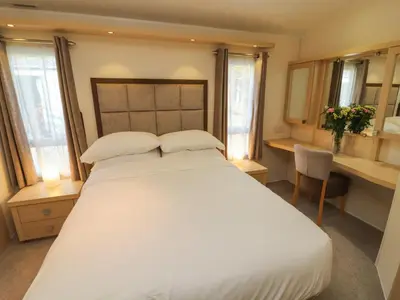 a bedroom with a large white bed with two pillows at Lodge 3 in Carnforth