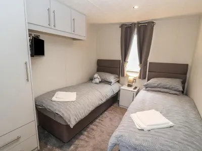 two beds in a small room with a tv at 24 Sherwood in Carnforth